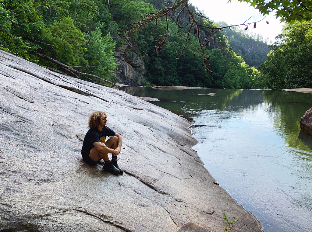 man sitting on rock in a gorge