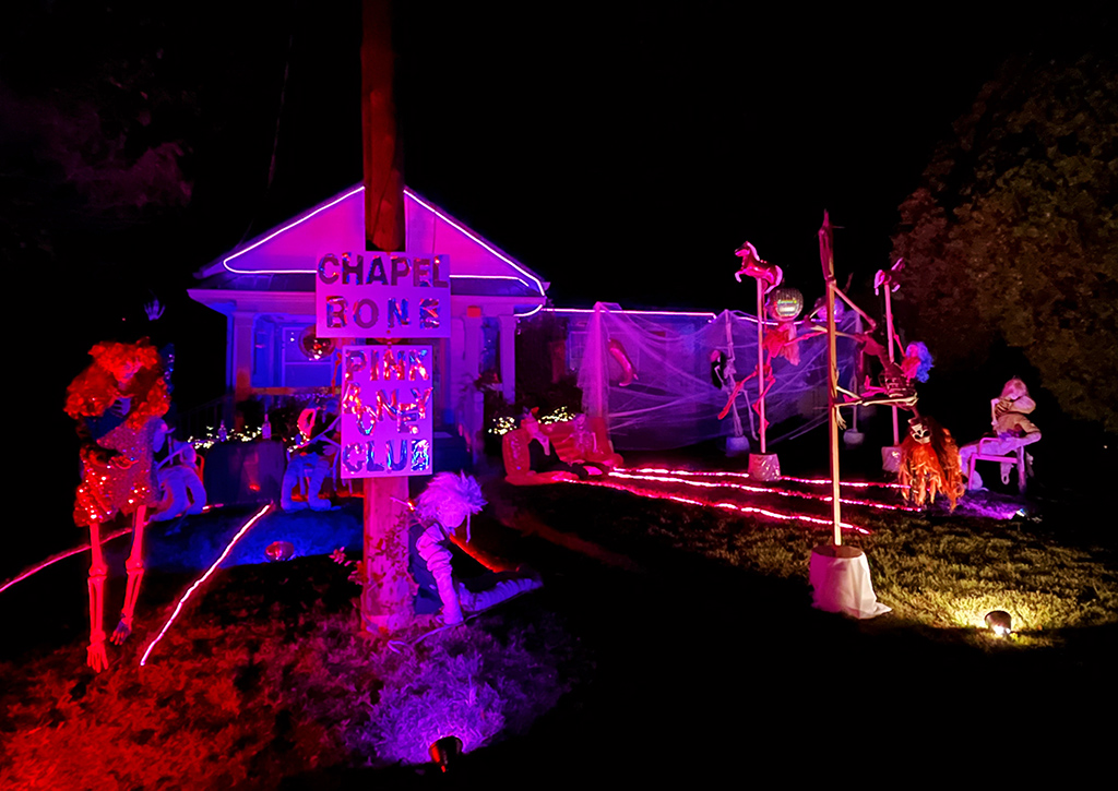 front yard decorated as a pink skeleton strip club
