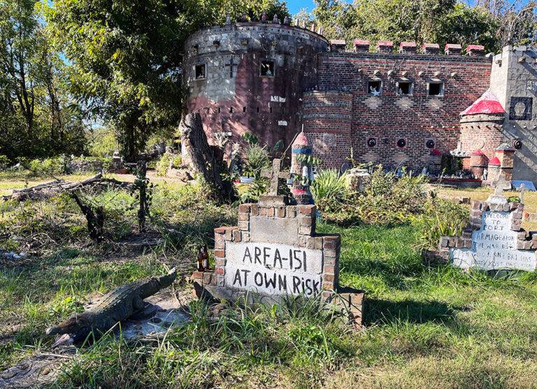 The front of Greenback Castle with a sign and gator statue in the front yard