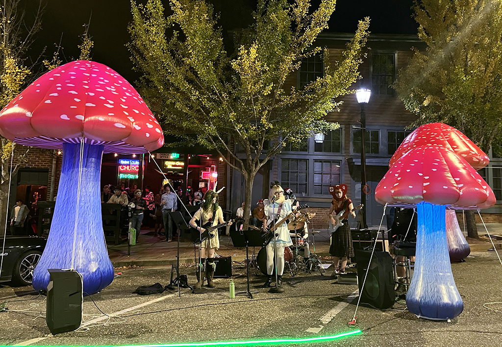 inflatable neon mushrooms and a band dressed as Alice in Wonderland characters