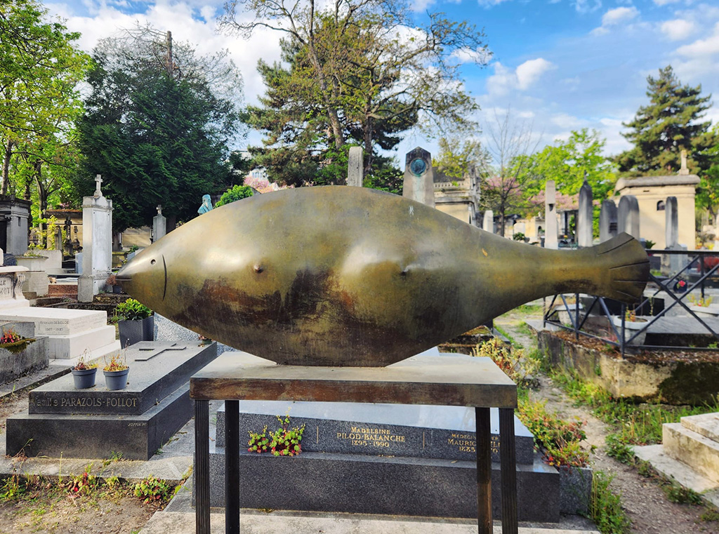 a bronze fish sculpture with human breasts