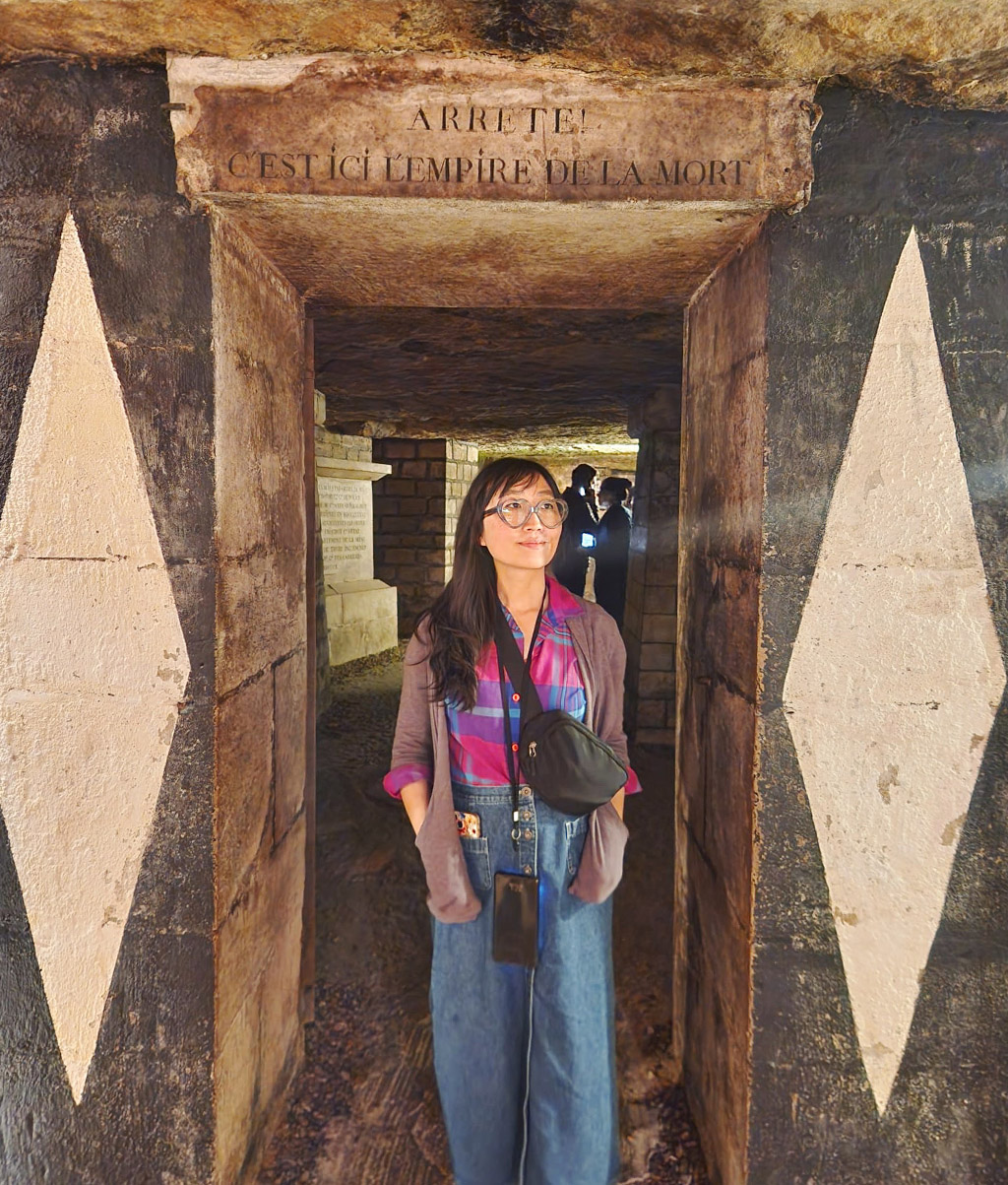woman standing in the doorway to the galleries at the Paris catacombs