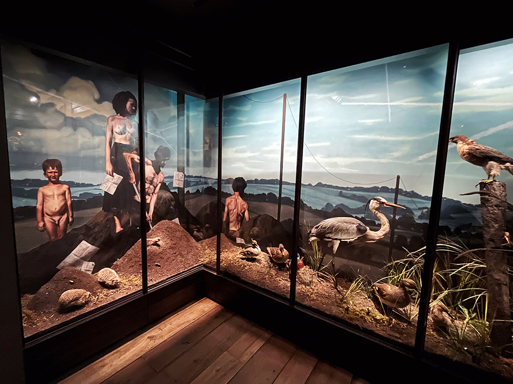 a nature diorama with a children, a woman, and birds