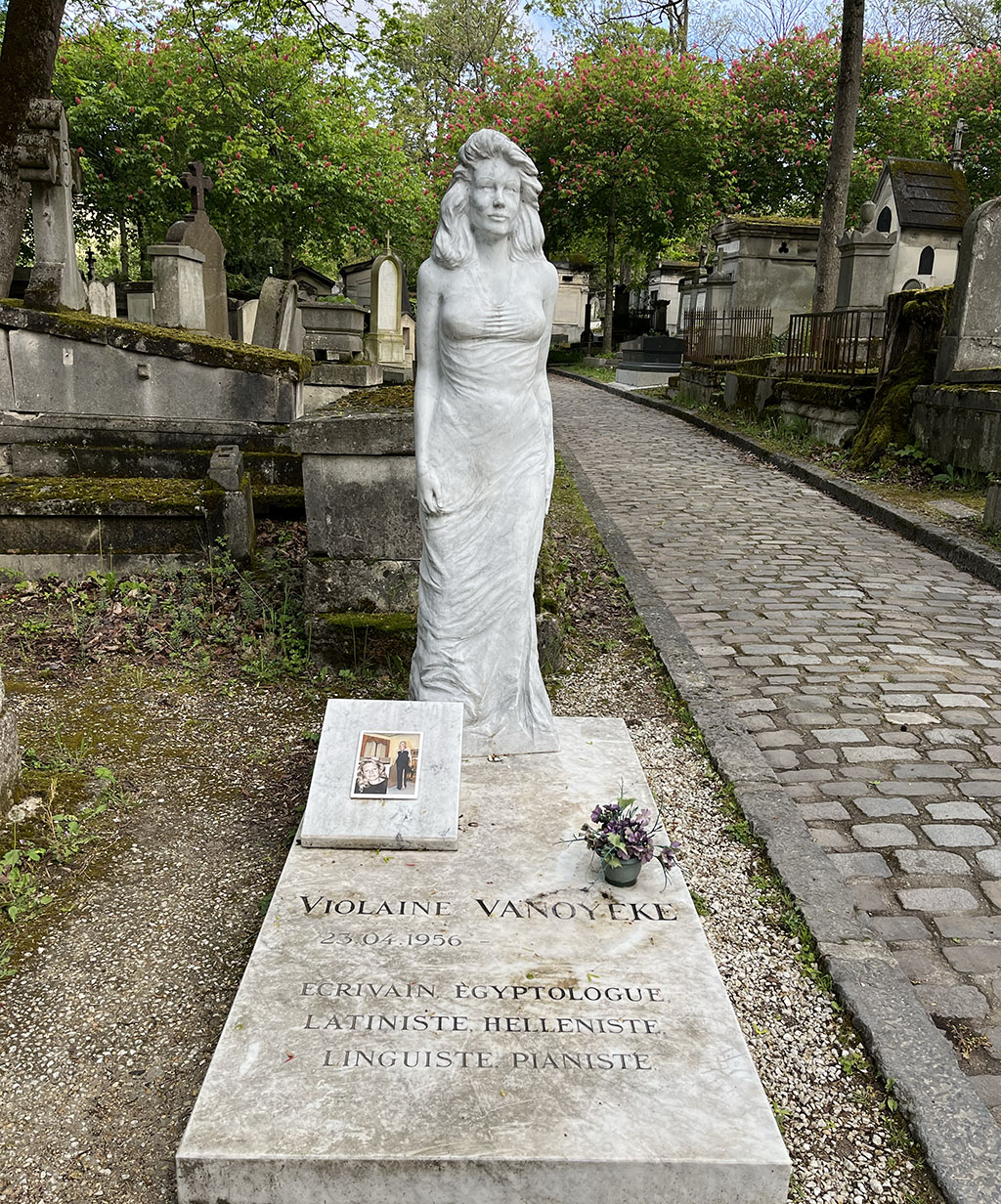statue of a woman in a full length dress over a grave