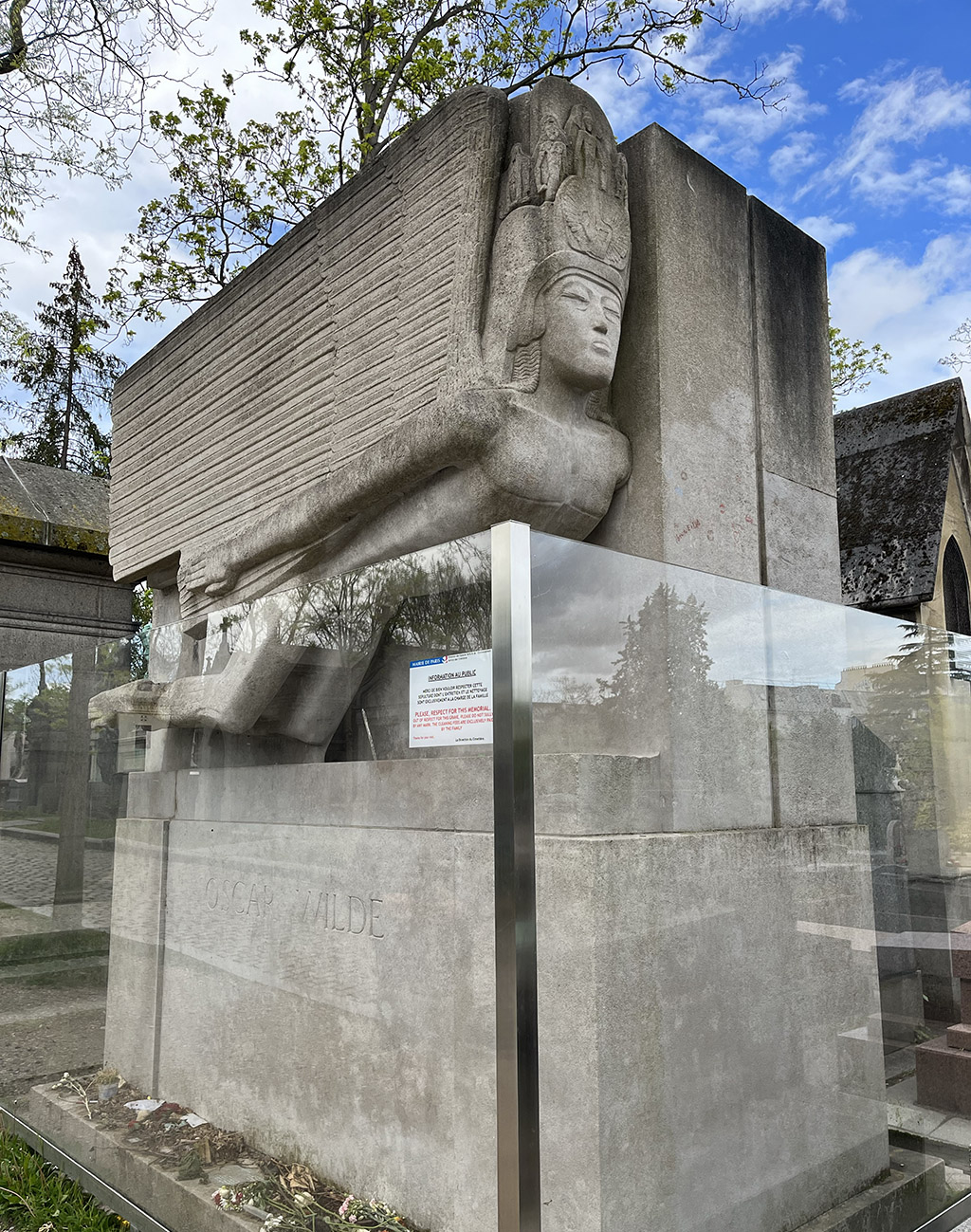 grave of Oscar Wilde, a modernist sphinx-like figure behind a glass barrier
