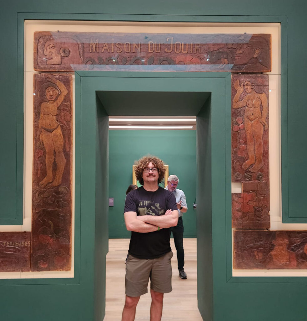 man standing under wooden carved doorway