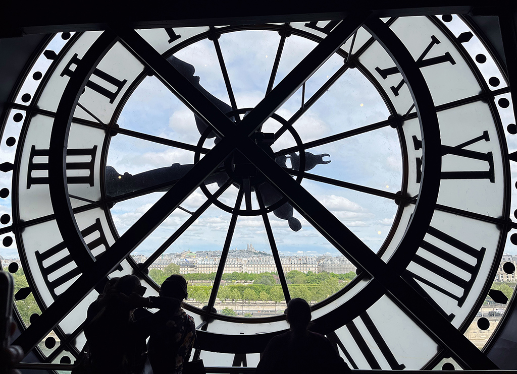 silhouettes of people looking out the large clock window at the Musee d'Orsay