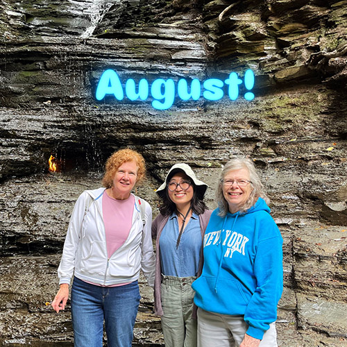 three women standing in front of eternal flame falls