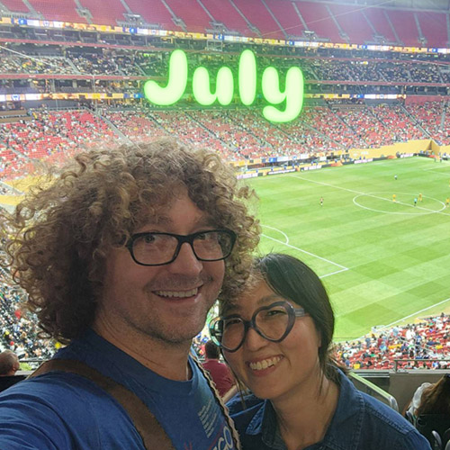 couple taking a selfie at a soccer stadium